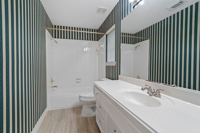full bath with toilet, wallpapered walls, vanity, and  shower combination