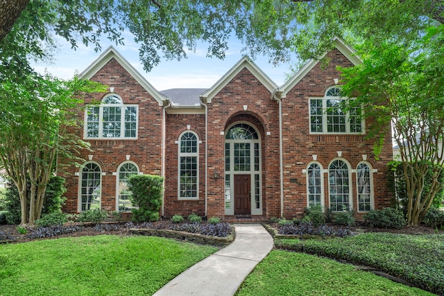 view of front of home with a front lawn and brick siding