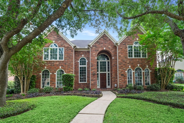 view of front of home featuring brick siding and a front yard