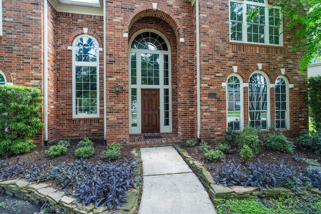 view of exterior entry featuring brick siding