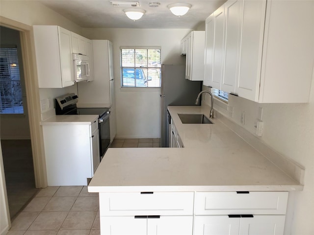 kitchen featuring white cabinetry, a sink, light countertops, electric range, and white microwave