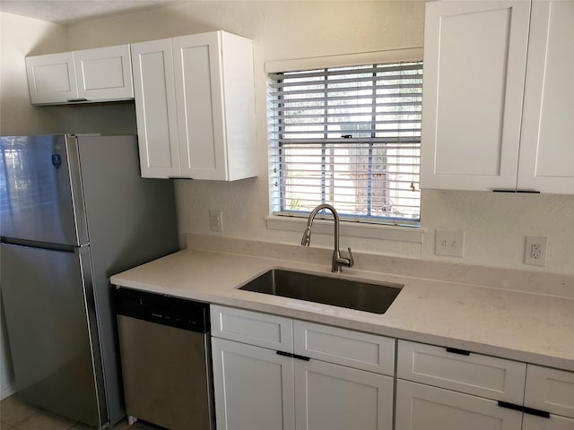 kitchen with a sink, white cabinets, and appliances with stainless steel finishes
