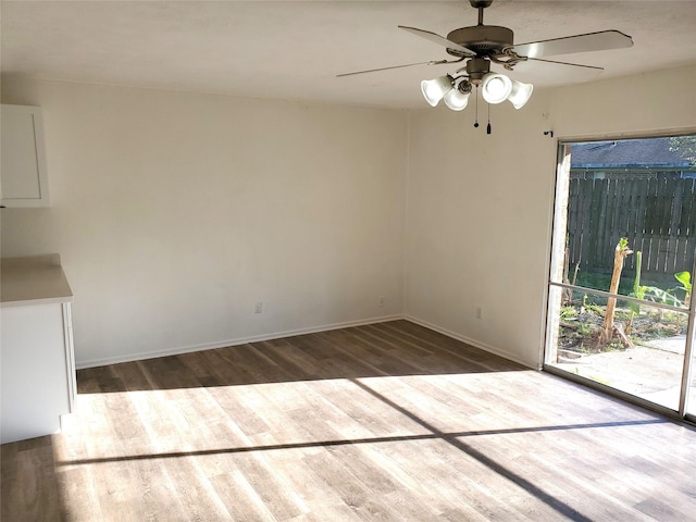 unfurnished dining area with baseboards, wood finished floors, and ceiling fan