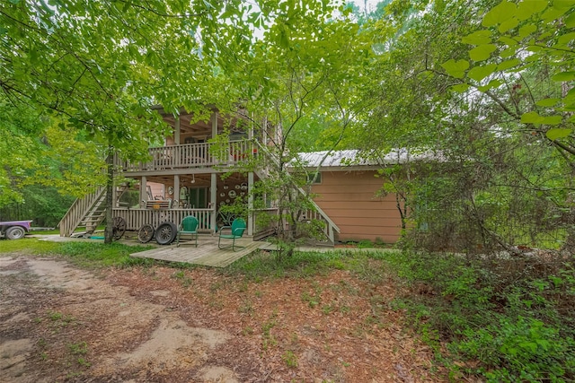 back of property featuring a wooden deck and stairs
