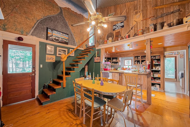 dining area featuring a ceiling fan, plenty of natural light, hardwood / wood-style floors, and a towering ceiling