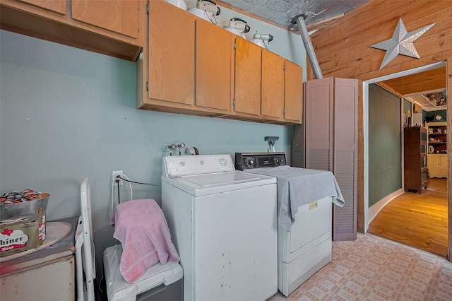 laundry area with light wood-type flooring, cabinet space, and washing machine and clothes dryer