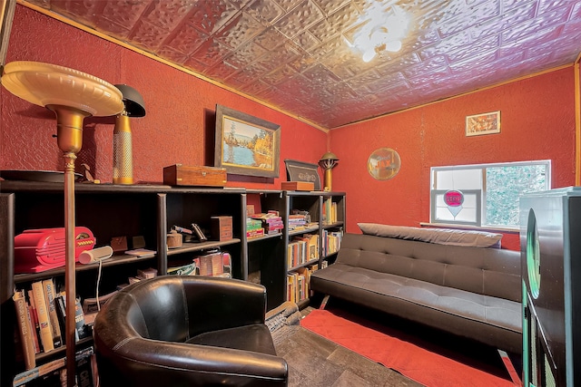 living area with an ornate ceiling and a textured wall