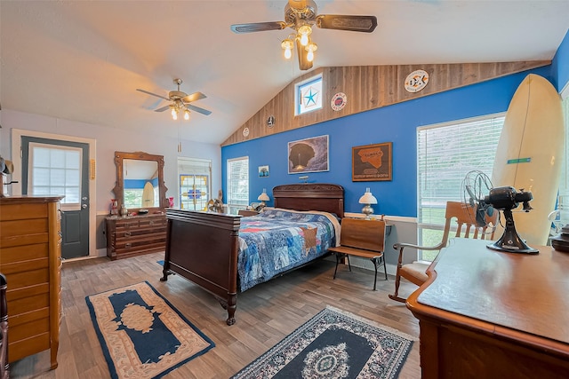 bedroom featuring baseboards, multiple windows, vaulted ceiling, and wood finished floors
