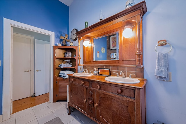 bathroom featuring backsplash, double vanity, tile patterned floors, and a sink
