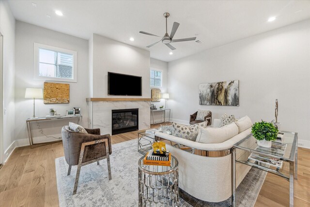 714 E 21st St, Houston, TX 77008 - living room featuring baseboards, light wood-style floors, ceiling fan, and a high end fireplace