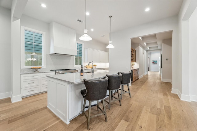 714 E 21st St, Houston, TX 77008 - kitchen featuring white cabinetry, a kitchen island with sink, light wood-style flooring, and a sink
