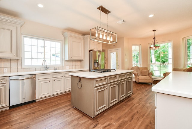 8819 Aubrey Ln, Richmond, TX 77469 - kitchen with tasteful backsplash, wood finished floors, appliances with stainless steel finishes, light countertops, and a sink