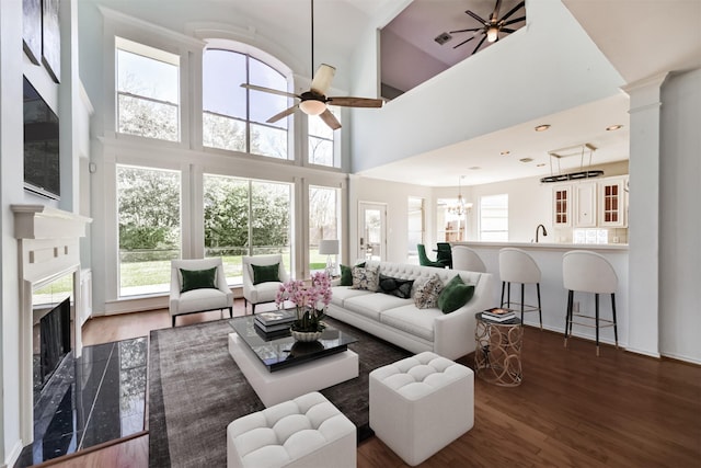 120 Calypso Ln, League City, TX 77573 - living room with a ceiling fan, a fireplace, healthy amount of natural light, wood finished floors, and a high ceiling