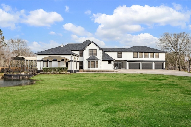 9108 Quail Ridge Dr, Manvel, TX 77578 - back of house with concrete driveway, roof with shingles, a lawn, an attached garage, and stucco siding