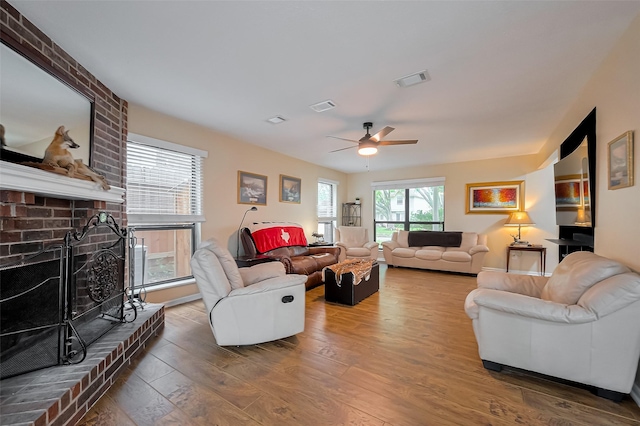 2307 Country Place Dr, Richmond, TX 77406 - living area featuring a fireplace, a ceiling fan, visible vents, and wood finished floors