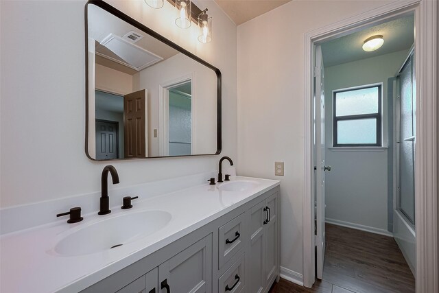 2307 Country Place Dr, Richmond, TX 77406 - bathroom with double vanity, visible vents, wood finished floors, and a sink