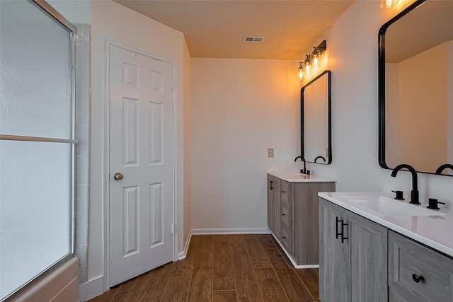 2307 Country Place Dr, Richmond, TX 77406 - full bath with a shower with door, visible vents, a sink, two vanities, and wood finished floors