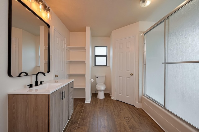 2307 Country Place Dr, Richmond, TX 77406 - full bathroom with a shower with shower door, toilet, wood finished floors, vanity, and baseboards