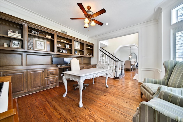 home office featuring crown molding, a ceiling fan, a wealth of natural light, and built in study area