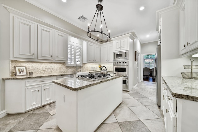 kitchen featuring crown molding, appliances with stainless steel finishes, white cabinetry, backsplash, and visible vents