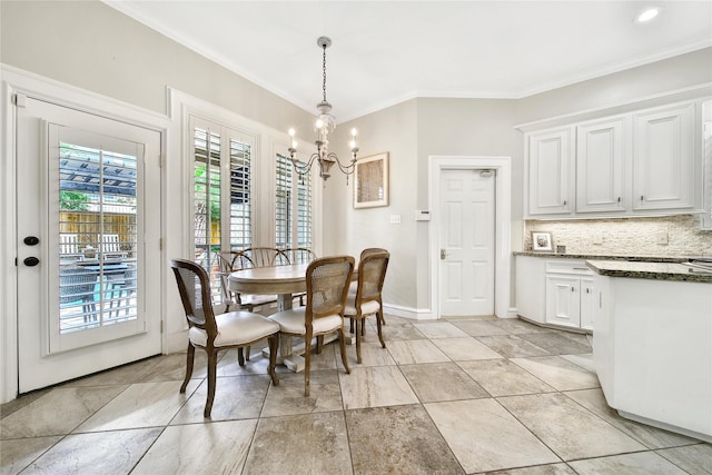 dining room featuring crown molding, baseboards, and a notable chandelier