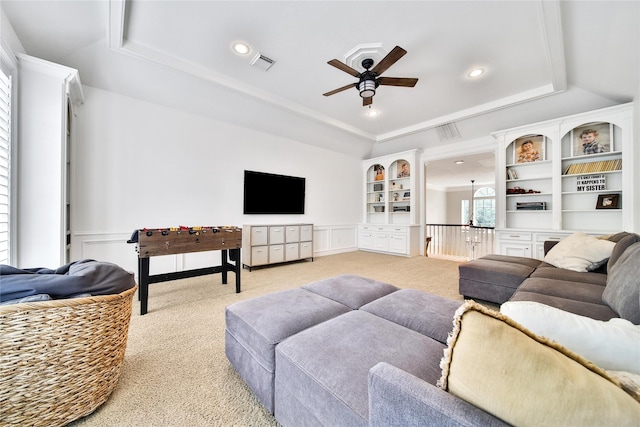 living room with visible vents, a raised ceiling, and light carpet