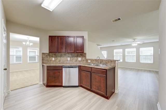 kitchen with a peninsula, a sink, stainless steel dishwasher, visible vents, and light wood-style floors