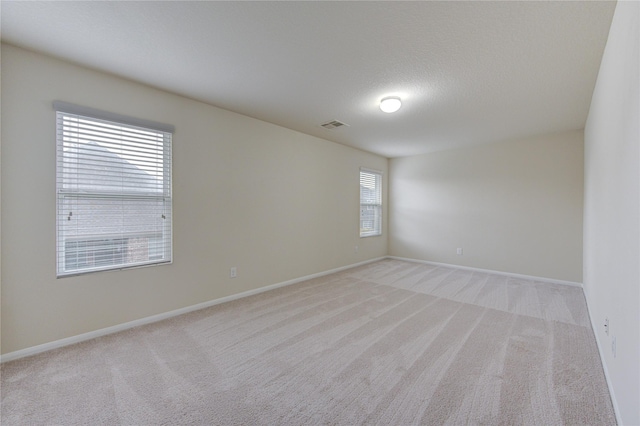 unfurnished room with light carpet, baseboards, and visible vents