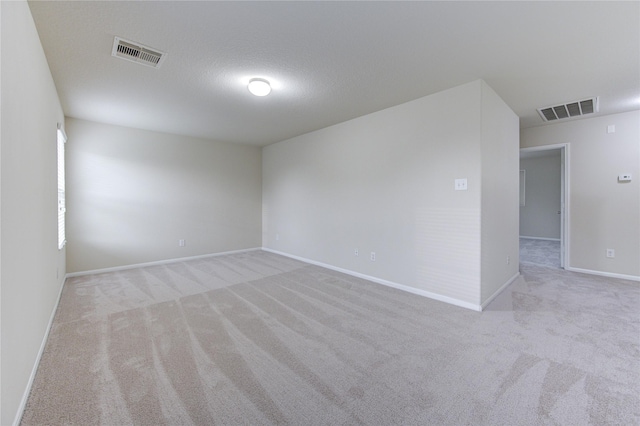 unfurnished room featuring carpet flooring, visible vents, and baseboards
