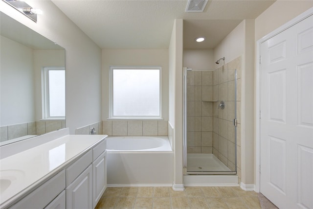 full bath with a stall shower, a garden tub, vanity, and visible vents