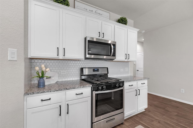 kitchen featuring tasteful backsplash, dark wood finished floors, light stone counters, white cabinets, and stainless steel appliances