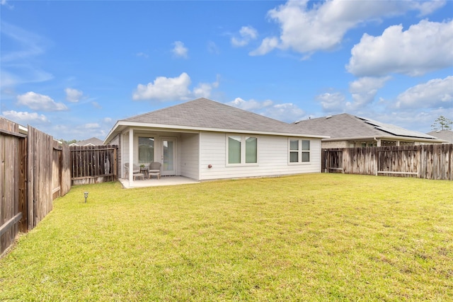 rear view of house with a lawn, a fenced backyard, and a patio area