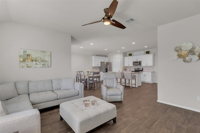living area featuring dark wood-style flooring, a ceiling fan, visible vents, and recessed lighting