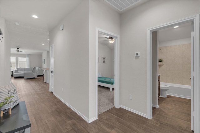 hall featuring recessed lighting, baseboards, wood finished floors, and visible vents