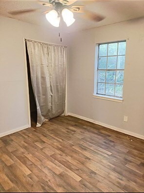 414 Future St, Palestine, TX 75801 - unfurnished bedroom featuring baseboards, a ceiling fan, and wood finished floors