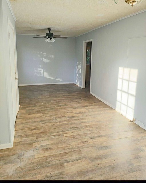 414 Future St, Palestine, TX 75801 - unfurnished room with crown molding, ceiling fan, baseboards, and wood finished floors