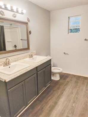 414 Future St, Palestine, TX 75801 - bathroom with double vanity, toilet, a sink, and wood finished floors