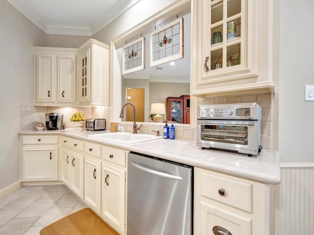 kitchen featuring tasteful backsplash, dishwasher, crown molding, and a sink