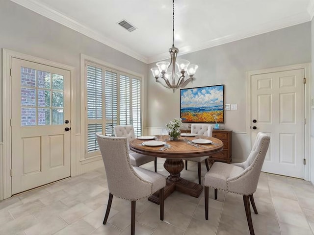 dining space with visible vents, ornamental molding, and an inviting chandelier