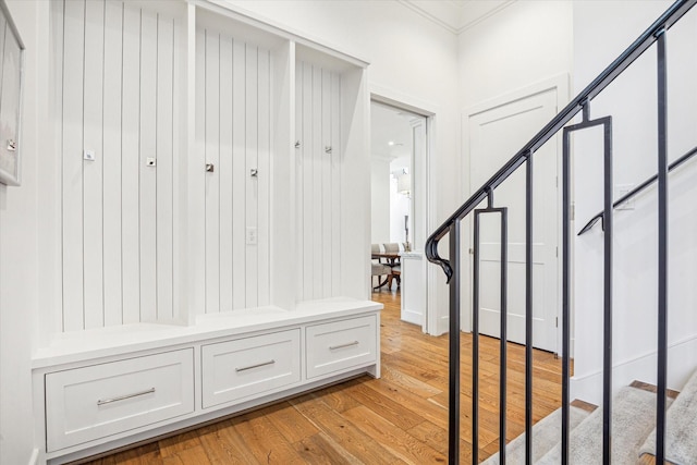 mudroom with crown molding and light wood finished floors