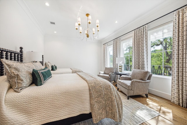 bedroom with an inviting chandelier, wood finished floors, ornamental molding, and multiple windows