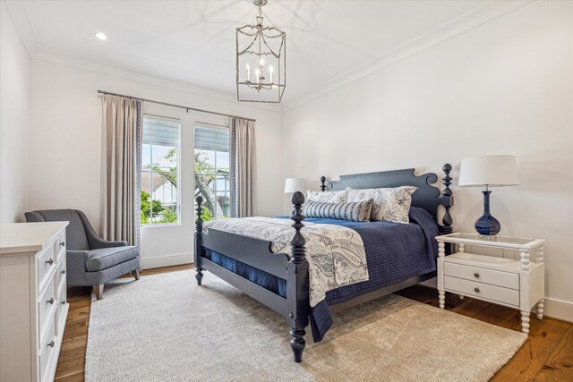 bedroom featuring ornamental molding, a notable chandelier, and wood finished floors