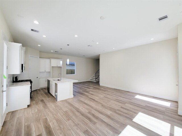 5931 Beall St A-B, Unit A-B Houston, TX 77091 - kitchen featuring a kitchen island with sink, light wood-style floors, gas stove, visible vents, and open floor plan