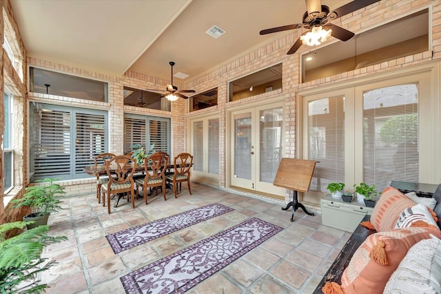 sunroom / solarium featuring french doors, a ceiling fan, outdoor dining space, and visible vents