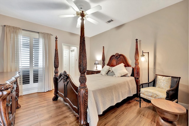 bedroom featuring a ceiling fan, visible vents, and light wood-style floors