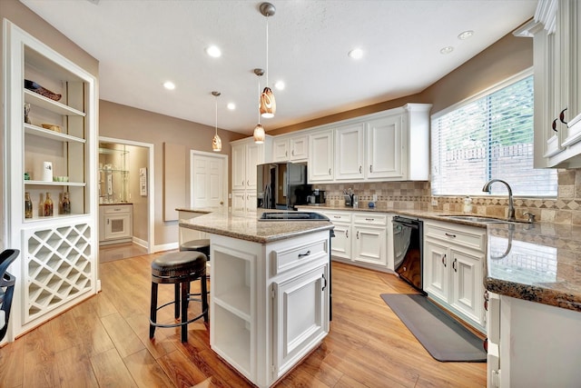kitchen with open shelves, a center island, white cabinets, a sink, and black appliances