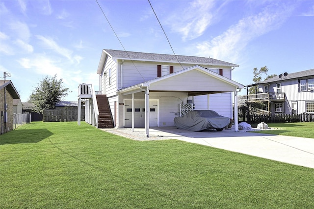 rear view of house featuring driveway, a yard, stairway, and fence