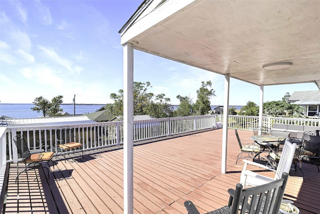 wooden terrace with outdoor dining space and a water view
