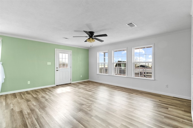 unfurnished living room featuring wood finished floors, visible vents, crown molding, and a ceiling fan