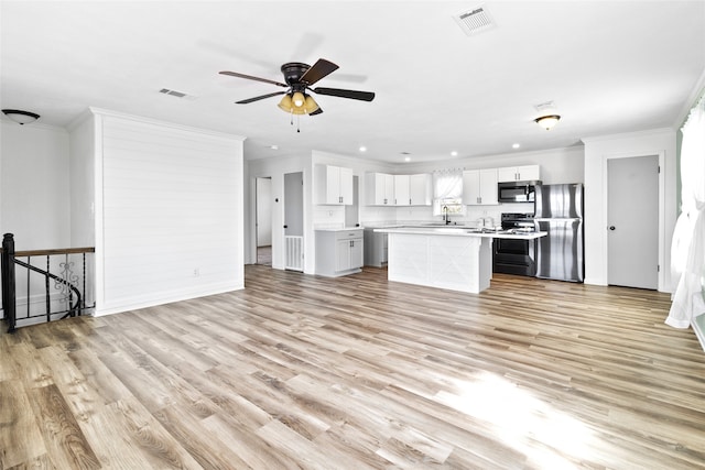 unfurnished living room with ornamental molding, visible vents, and light wood-style floors